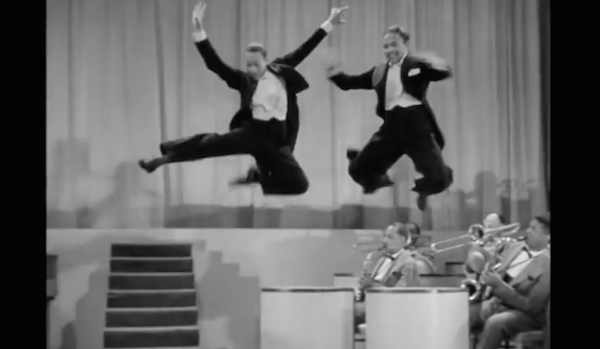 Two dancers jump in the air
