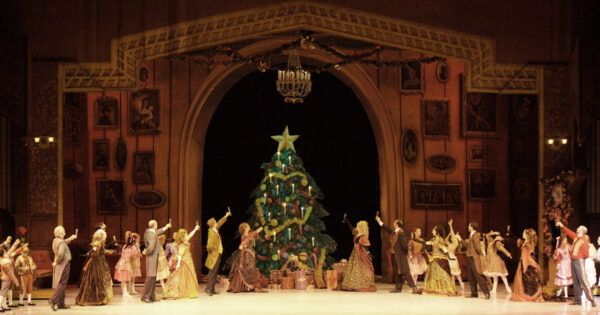 A Christmas party with guests around the tree in The Nutcracker