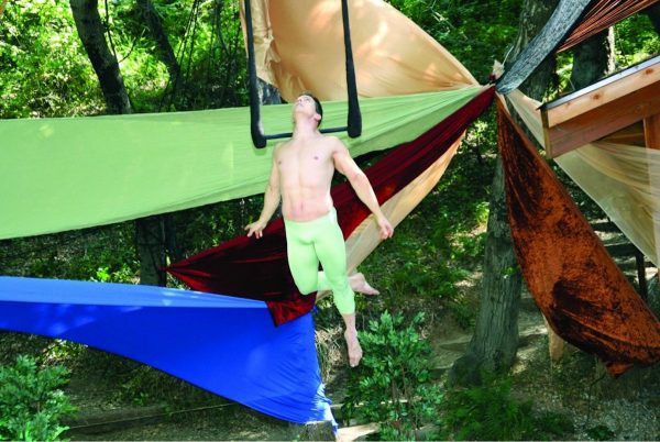 A man hangs from a trapeze