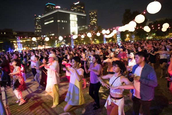 A group of dancers below circular lights