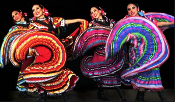 Women dancers twirl long multi-colored skirts