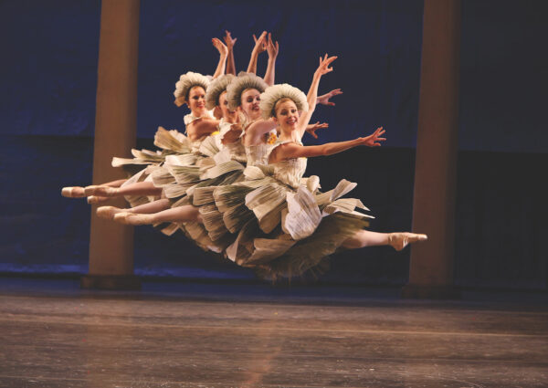 A row of dancers as flowers leap in The Nutcracker