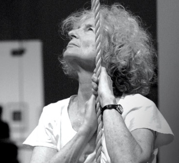 A woman with a rope looks upward