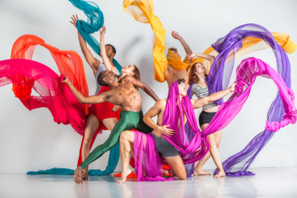 A group of dancer toss colorful scarves