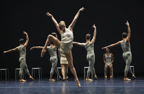 A dancer in white in front of other dancers