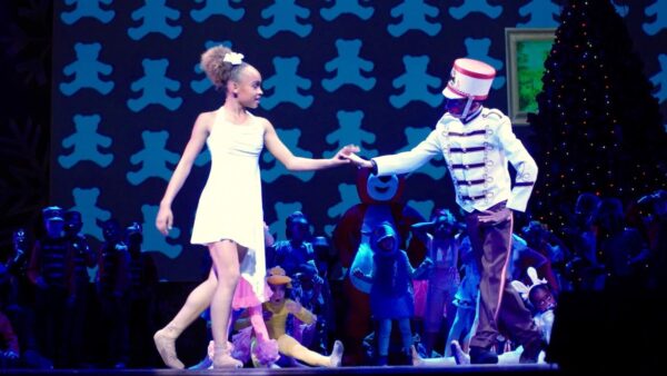 A Black boy in a soldier suit bows to a young Black girl in Hot Chocolate Nutcracker