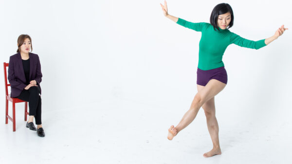 A dancer in black trunks and green shirt