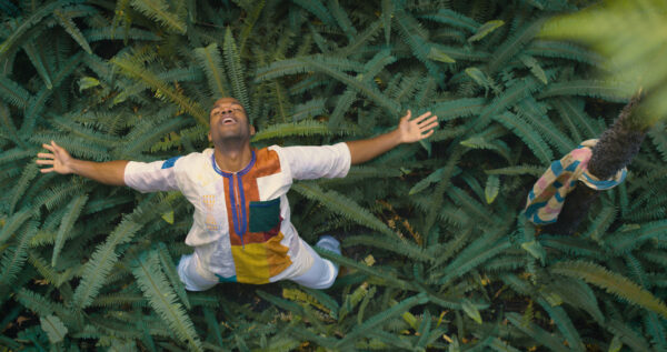 A man looks upward and extends his arms