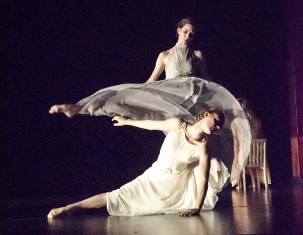 A group of dancers in white kneel
