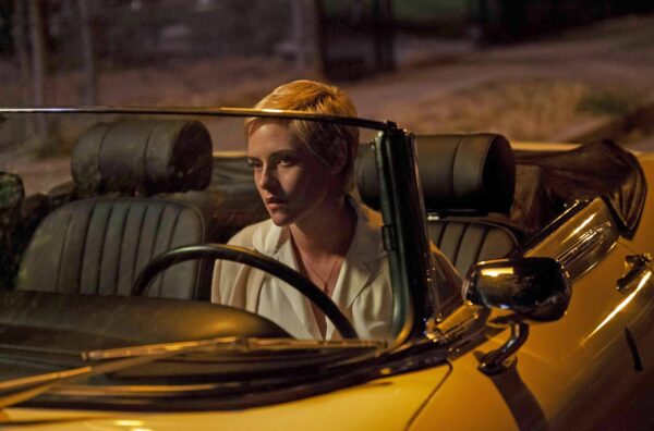 Image of actress Kristen Stewart sitting in a yellow convertible, looking off to the left of the frame.