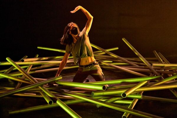 A woman emerges from a pile of pipes
