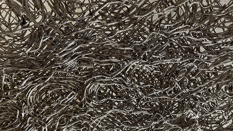A dense weaving of chain that looks like worms twisting around each other in a cup.
