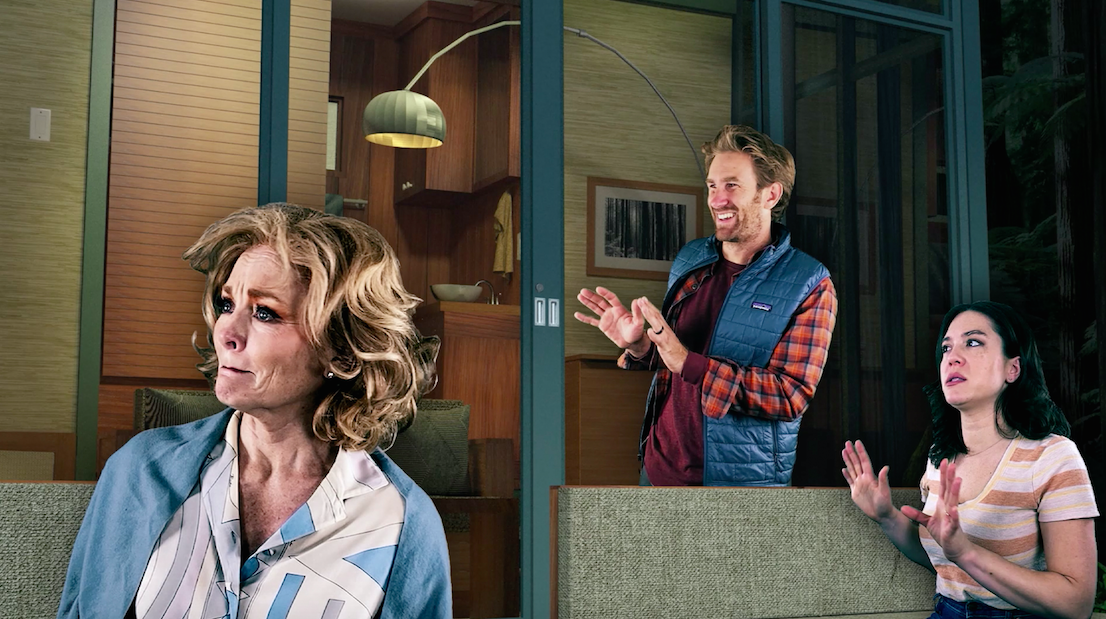 Three people, seemingly a family, are each displaying a different emotion: the older woman to the left is is overwhelmed, the man in the middle is amused, and the younger woman to the right is hesitant.