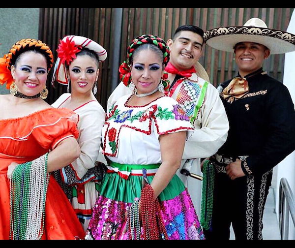 Three women and two men in different, traditional Mexican folkloric costumes.