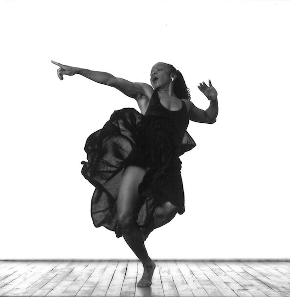 A woman in a black dress dances