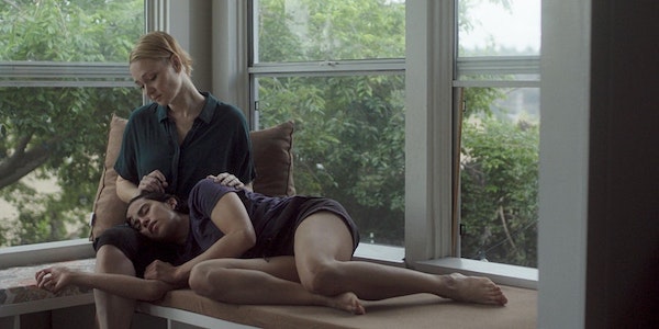 A woman lies in the lap of another woman
