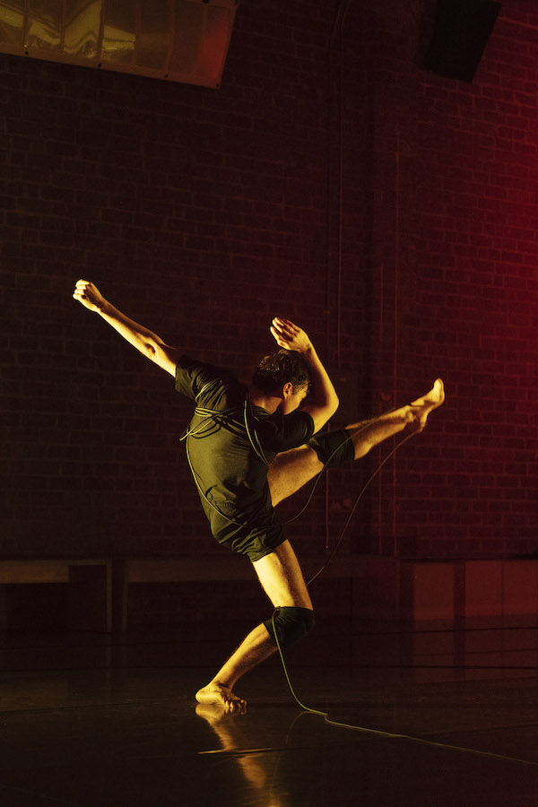 A man in black kicks his leg