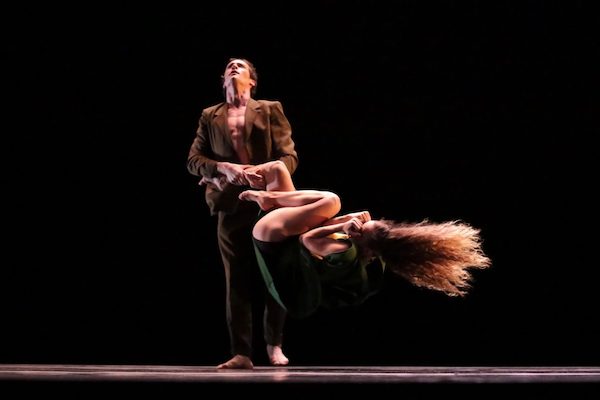 A man swings a woman, both Martha Graham Dance company members, by one leg