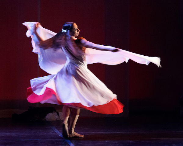 A woman spins in a multi-layered dress