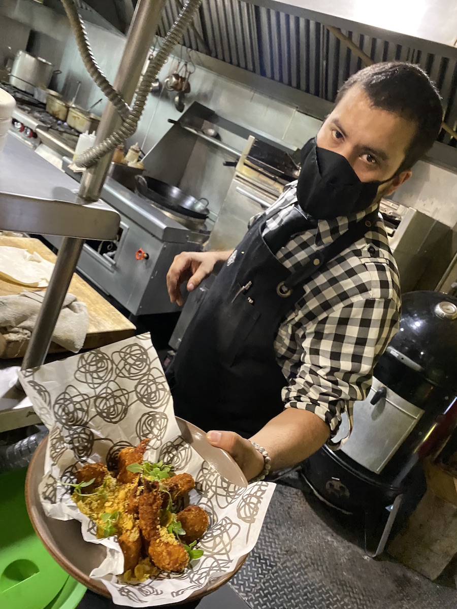 A Nudo Negro chef in the upper kitchen displays a dish of food