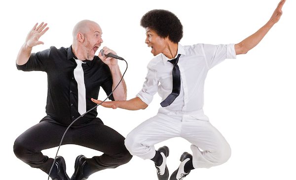 One man in tap shoes and another man with a microphone jump