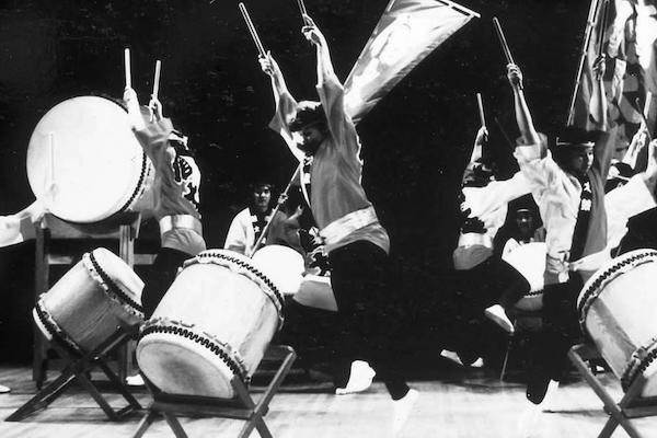 Drummers lift their drumsticks