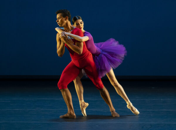 A man in red has a woman in purple holding onto his back