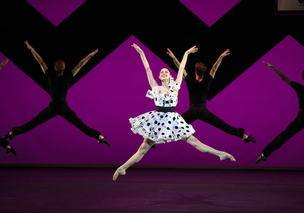 A woman in a polka dot dress leaps