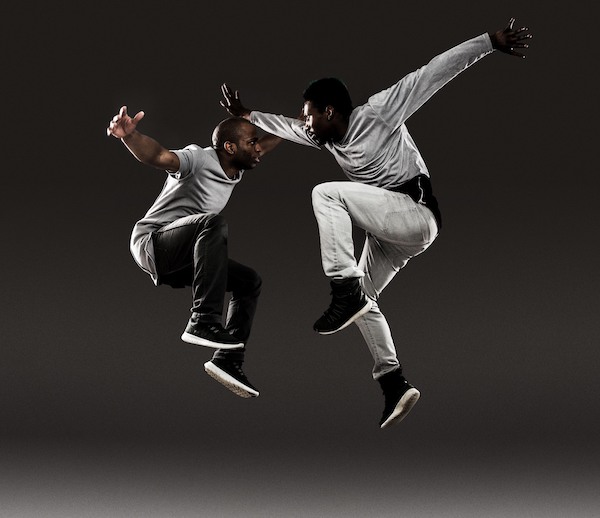 Two men jump in the air