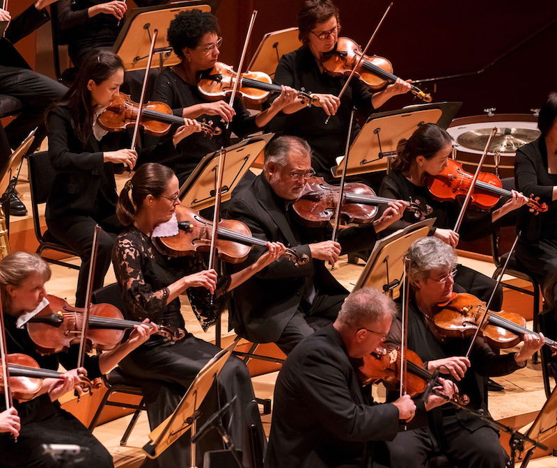 A photo of the Los Angeles Philharmonic playing instruments