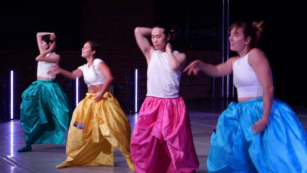Four dancers in different colored pants dance