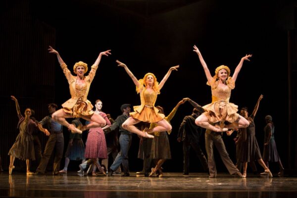 Three dancers leap in the air