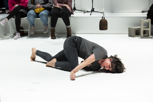A dancer in black crawls