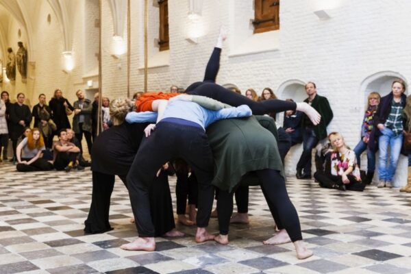 Dancers huddle in a piazza