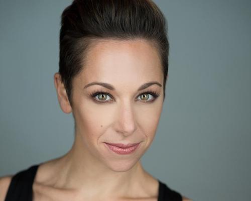 A woman with short dark hair looks at the camera