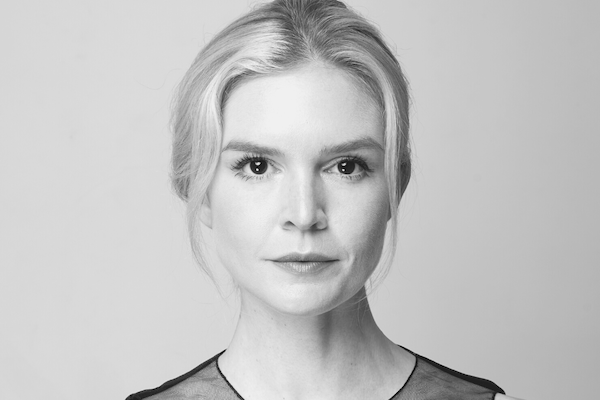 A blonde woman looks at the camera