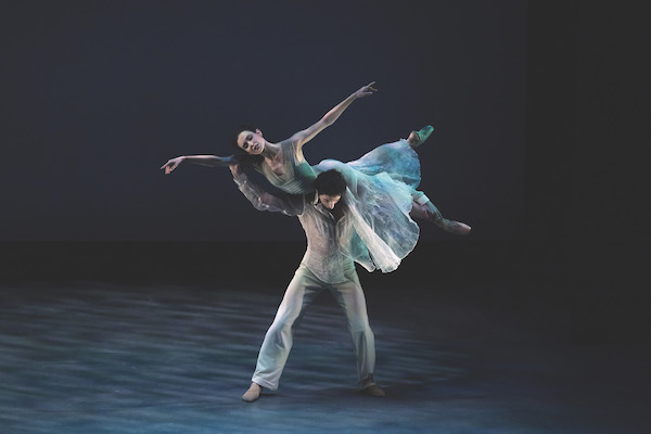 A man lifts a woman in white