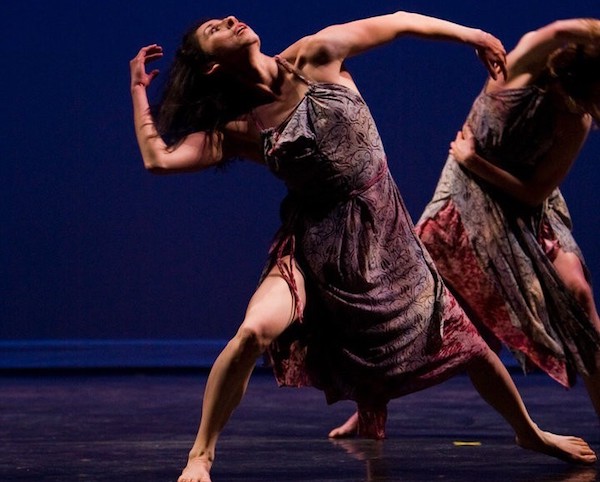 A woman dancer bends back and looks up