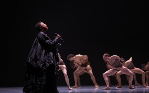 A singer in black with dancers