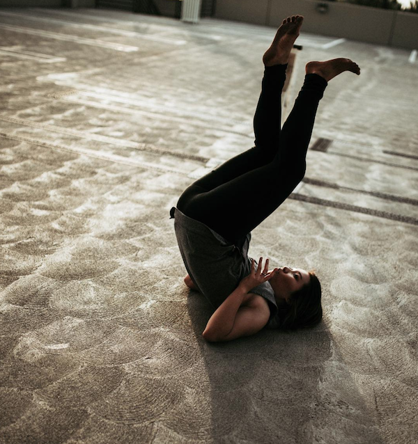 A dancer on her back with legs in the air