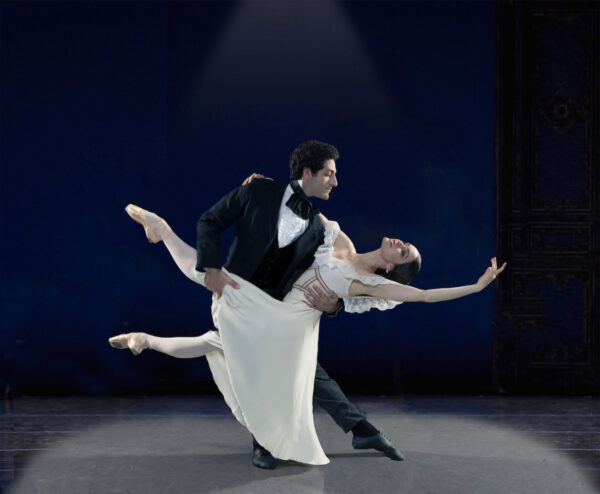 A man holds a woman in white