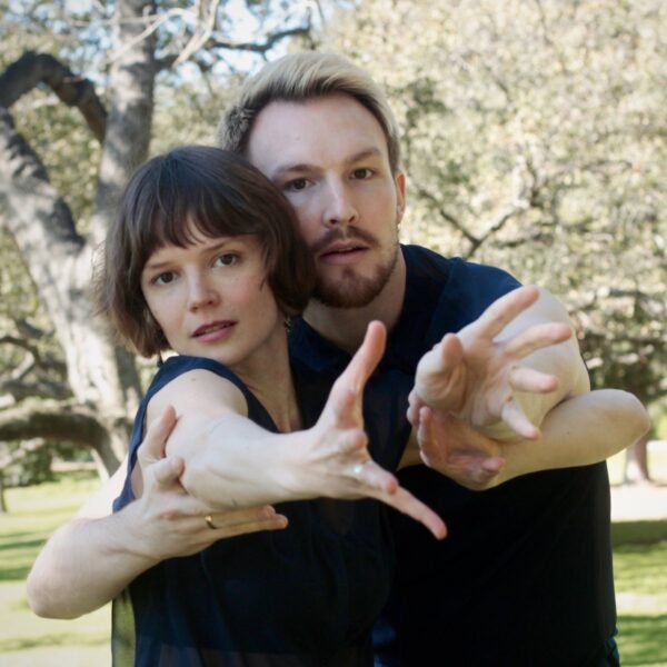 A man and woman reach toward the camera