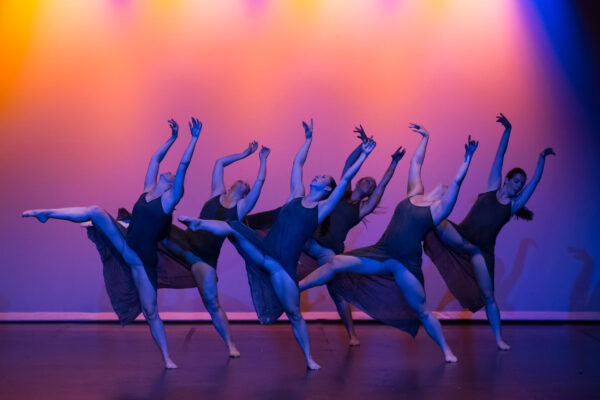 A group of dancers against a sunset backdrop