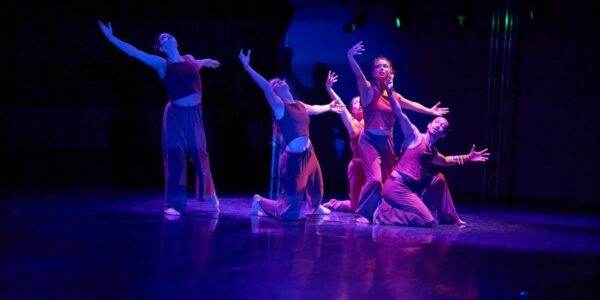 Dancers against a purple blue background