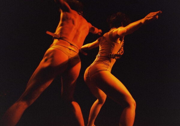 Two red-lit figures dance
