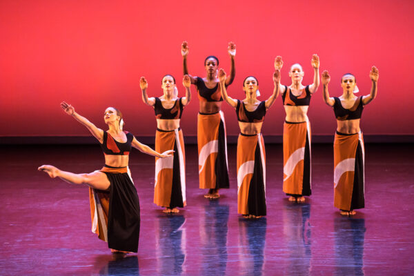 Dancers hold their hands and arms up