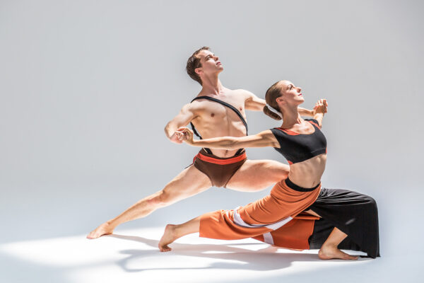 A bare-chested man supports a female dancer