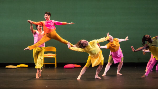 Dancers in yellow and pink jump around
