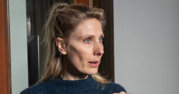 A woman looks slightly away from the camera