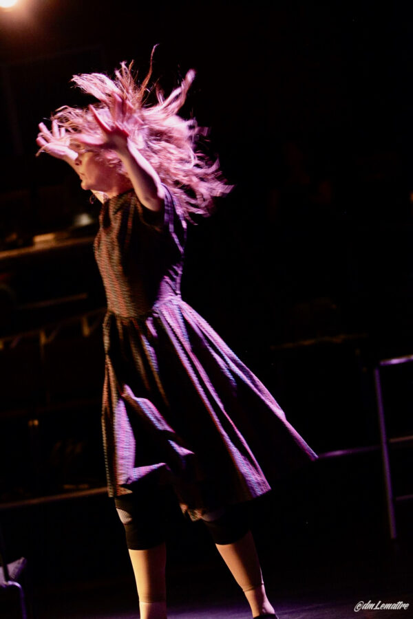 A dancer in a purple dress swings her hair